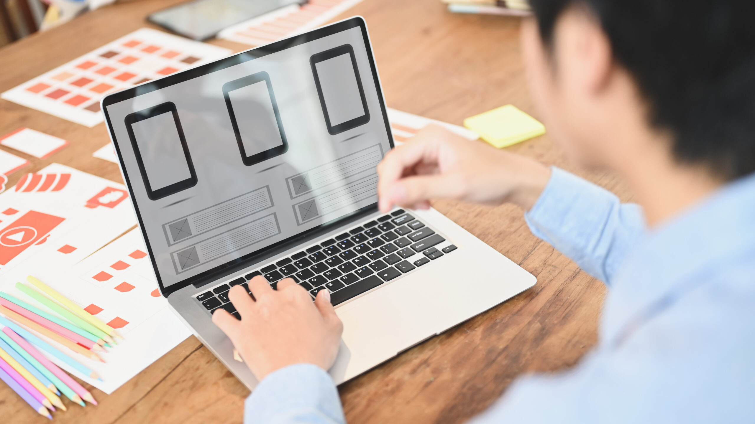 Ein Mann sitzt vor seinem Rechner und nutz einen Webpage Builder